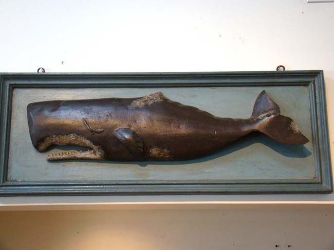 A wonderful contemporary hand carved sperm whale mounted on an antique backboard